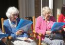 Residents Joan Hills, left, and Sheila Nell in fine voice as members of the Braemar Singing Group who performed at the garden party