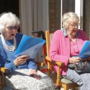 Residents Joan Hills, left, and Sheila Nell in fine voice as members of the Braemar Singing Group who performed at the garden party