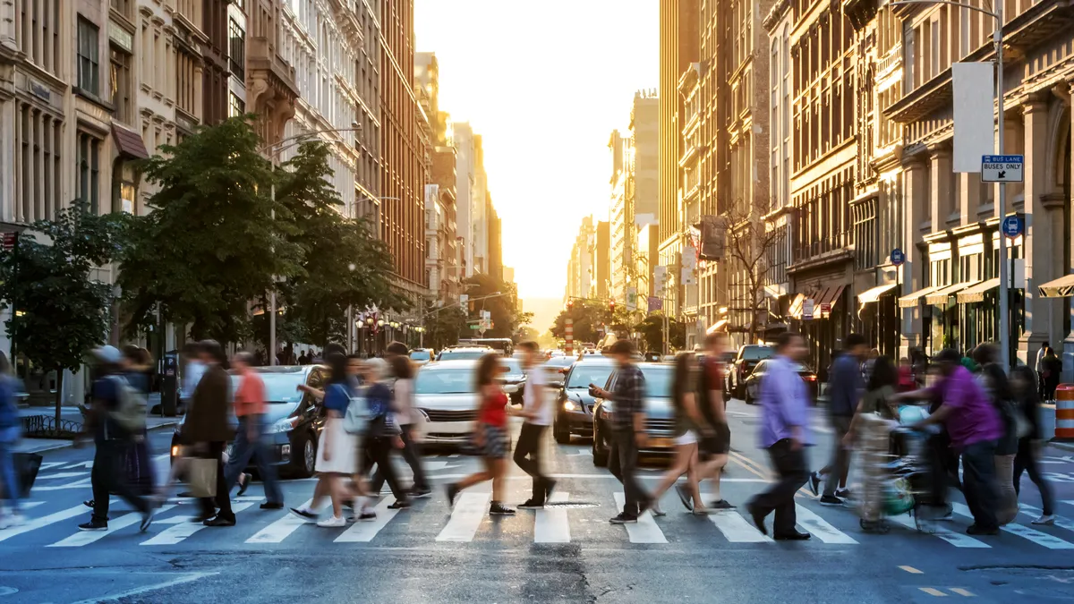 People walking across a busy crosswalk in New York City.