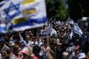 Demonstrators march with Israeli flags during a protest marking nine months since the start of the war and calling for the release of hostages held in the Gaza Strip by the Hamas militant group, in Tel Aviv, Israel (Leo Correa/AP)