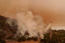 A helicopter drops water on flames from the advancing Lake Fire in Los Olivos, California (Eric Thayer/AP)