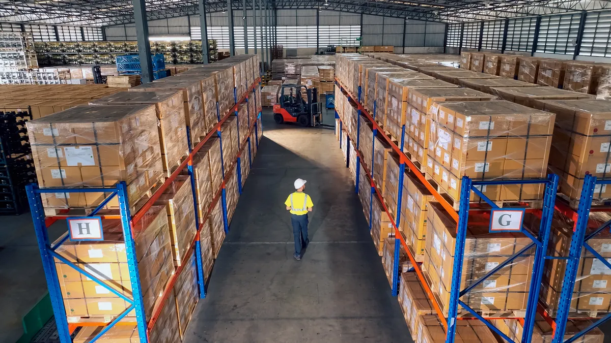 Aerial view of warehouse workers working and walking in a distribution center.