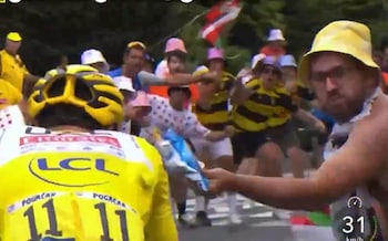 Tadej Pogacar has crisps thrown at him by a roadside spectator