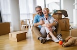 Happy couple with moving boxes at home