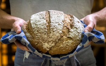 A baker with warm bread just out of the oven