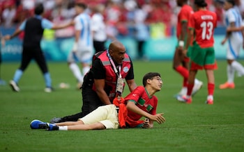 A steward catches a pitch invader 