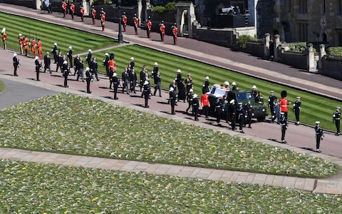 The Duke of Edinburgh's coffin, covered with his Personal Standard, is carried on the purpose built Land Rover Defender