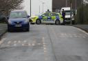 A police car blocks the road