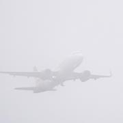 A plane takes off in misty conditions from  Gatwick airport