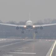 A plane lands in misty conditions at Gatwick Airport