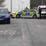 A police car blocks the road