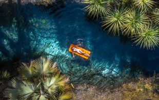 A woman floats on a inflatable bed in Bitter Springs, Elsey National Park