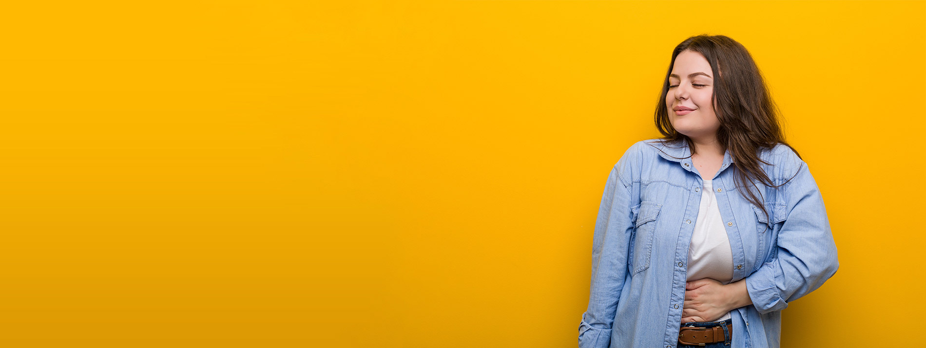 Right-aligned portrait of a smiling woman in a blue cardigan with a strong orange background.