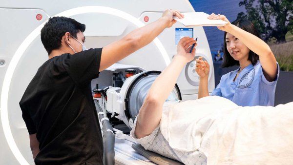 A doctor and technician set up an ultrasound on an MRI machine.