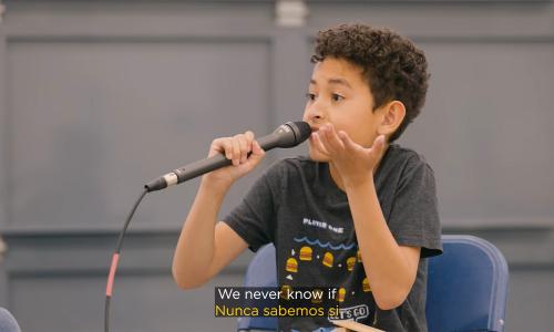 A still from the video Sea level rise, explained by kids showing a kid holding a microphone.