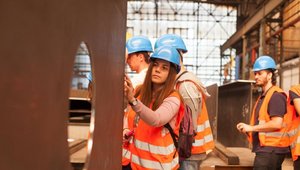 Studierende während Exkursion im Stahlwerk, Studierende schaut sich Stahl genau an