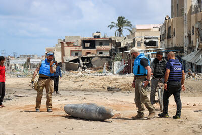 A UN team inspects an unexploded 1,000-pound bomb lying on a main road in Khan Younis, Gaza