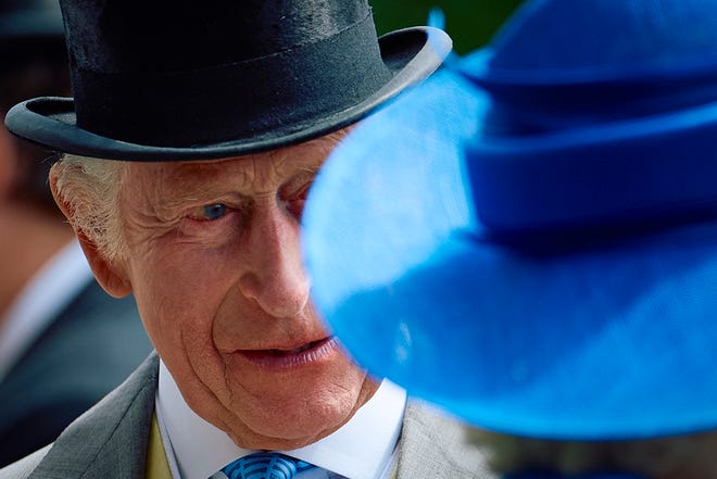 Britain's King Charles III reacts behind Britain's Queen Camilla, upon arrival to attend the first day of the Royal Ascot horseracing meeting in Ascot, west of London, on June 18, 2024.