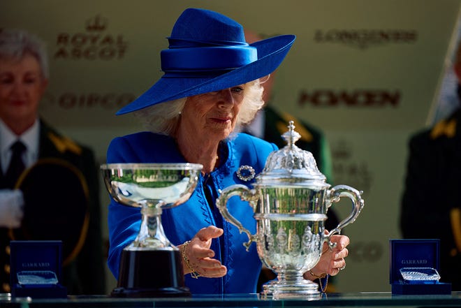 Britain's Queen Camilla looks at the trophy for the Saint James's Place Satakes (Group 1) on the first day of the Royal Ascot horse racing meeting, in Ascot, west of London, on June 18, 2024.