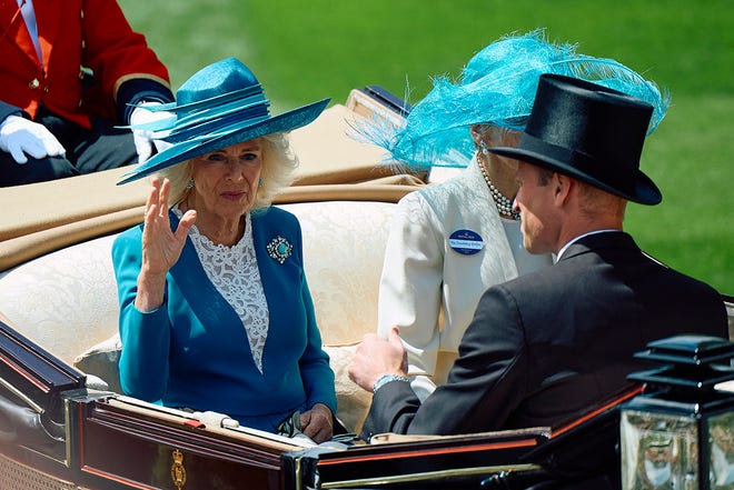 Britain's Queen Camilla waves as she arrives by carriage during the royal procession to attend the second day of the Royal Ascot horse racing meeting, in Ascot, west of London, on June 19, 2024.