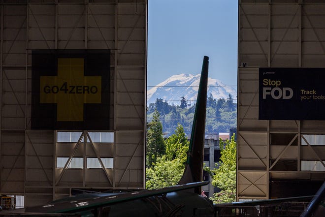 Mount Rainier looms outside the cracked open factory door as production of 737 MAX aircraft takes place at the Boeing 737 factory Tuesday, June 25, 2024 in Renton, WA.