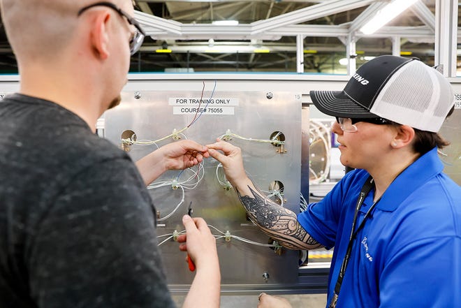 Patrick Hough, left, gets instruction from Kayla Abusham as he trains on the electrical systems at the Foundational Training Center Tuesday, June 25, 2024 in Renton, WA.