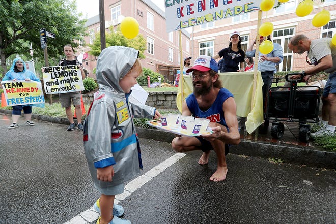 A young supporter gets a cup of lemonade at lemonade stand for Independent Presidential candidate Robert F. Kennedy near where the CNN Presidential Debate between President Joe Biden and former President Donald Trump will be held at CNN's studios in Atlanta.