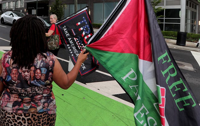 A Trump supporter walks past a pro-Palestine rally during the CNN Presidential Debate between President Joe Biden and former President Donald Trump held at CNN's studios in Atlanta. The rally was held just blocks away from the debate on the corner of Spring and 10th Street on June 27, 2024.