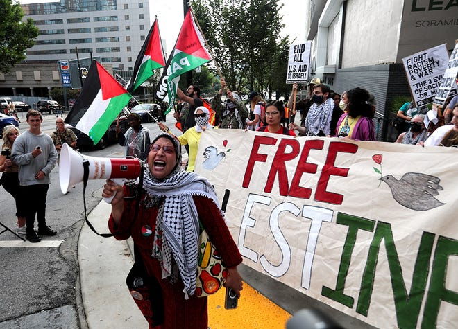 A pro-Palestine supporter screams into a bullhorn during a rally on the corner of Spring and 10th Streets just blocks from the CNN Presidential Debate between President Joe Biden and former President Donald Trump held at CNN's studios in Atlanta on June 27, 2024.