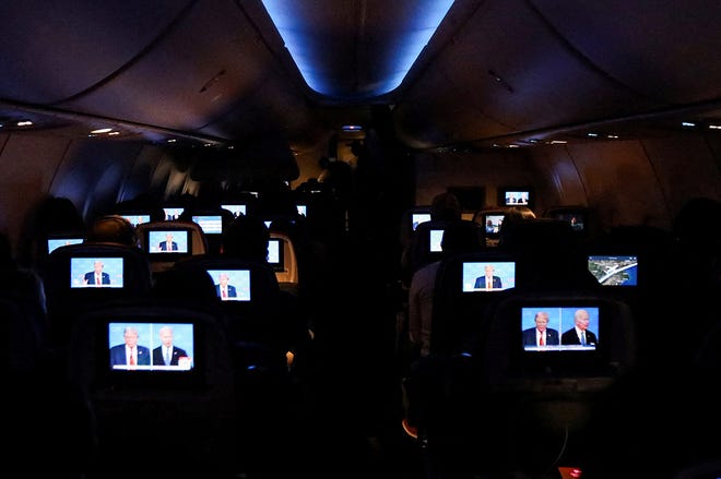 People watch the U.S. presidential debate aboard a Delta Airlines flight to Miami on June 27, 2024.