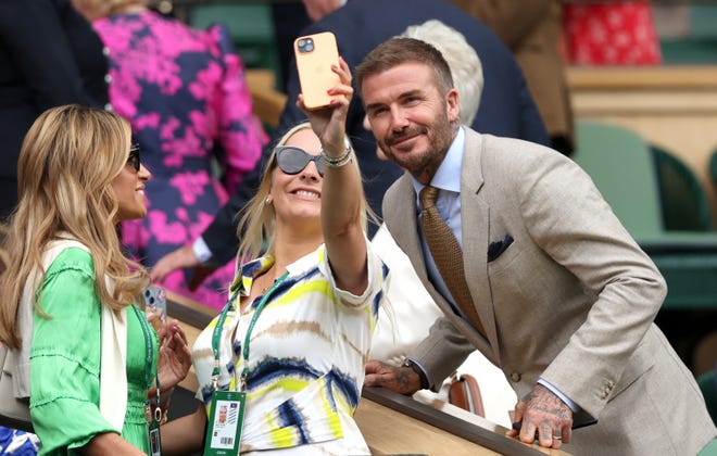 David Beckham poses for a selfie with a fan at Wimbledon.