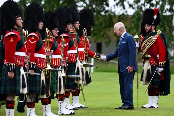 King Charles III inspects a guard of honour formed by members of The Band of the Royal Regiment of Scotland during the Ceremony of the Keys.