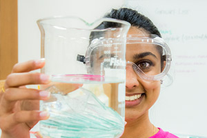 A woman holds a beaker