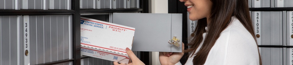 A person retrieving an item from a PO box.