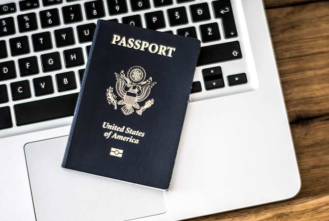 A passport lying on a laptop keyboard.