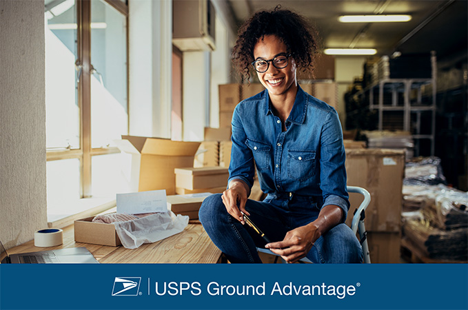 USPS Ground Advantage. A person surrounded by shipping boxes.