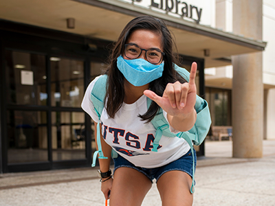 Student wearing mask doing birds up hand