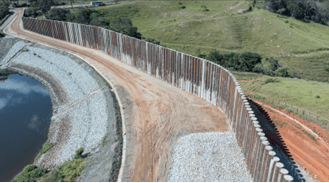 Aerial view of a containment fence dividing the green area from the lake