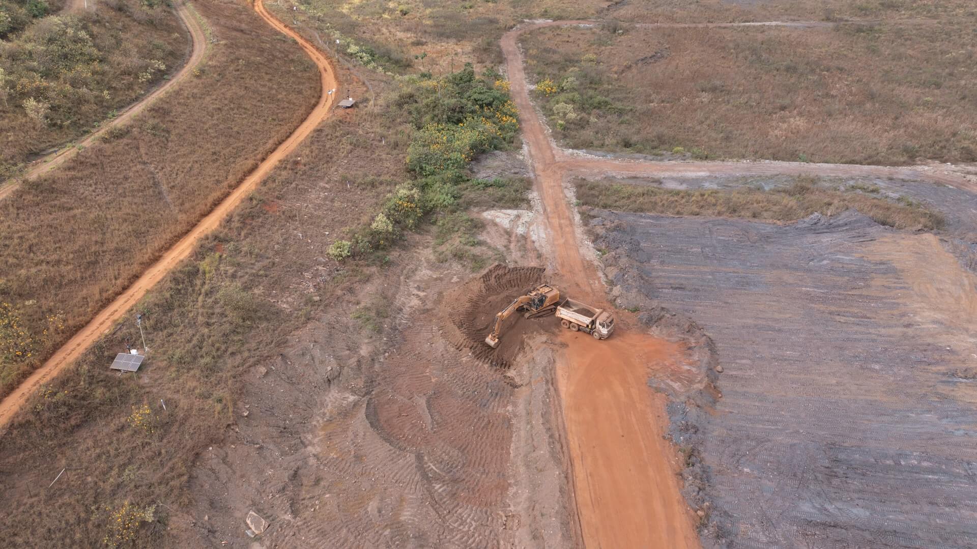 Tractor and truck digging in a sandy area