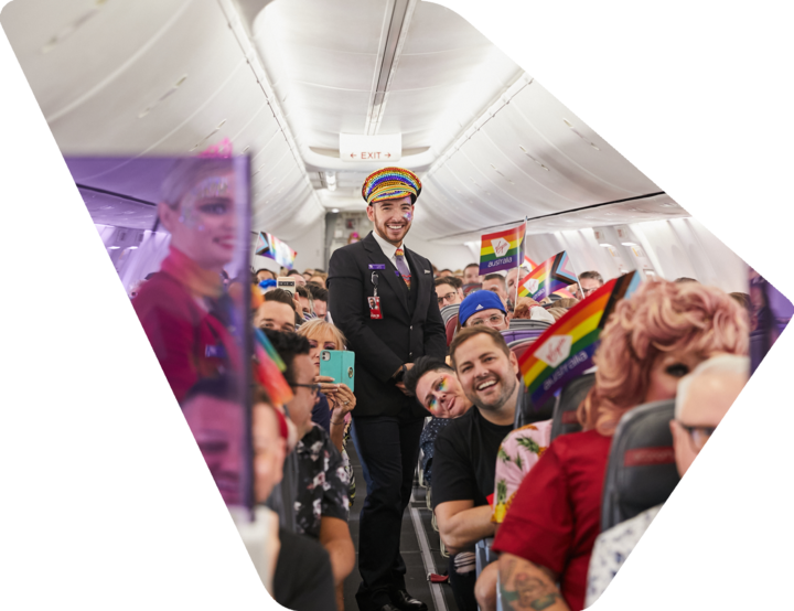 Cabin crew standing in aisle with sitting passengers on Virgin Australia Pride Flight