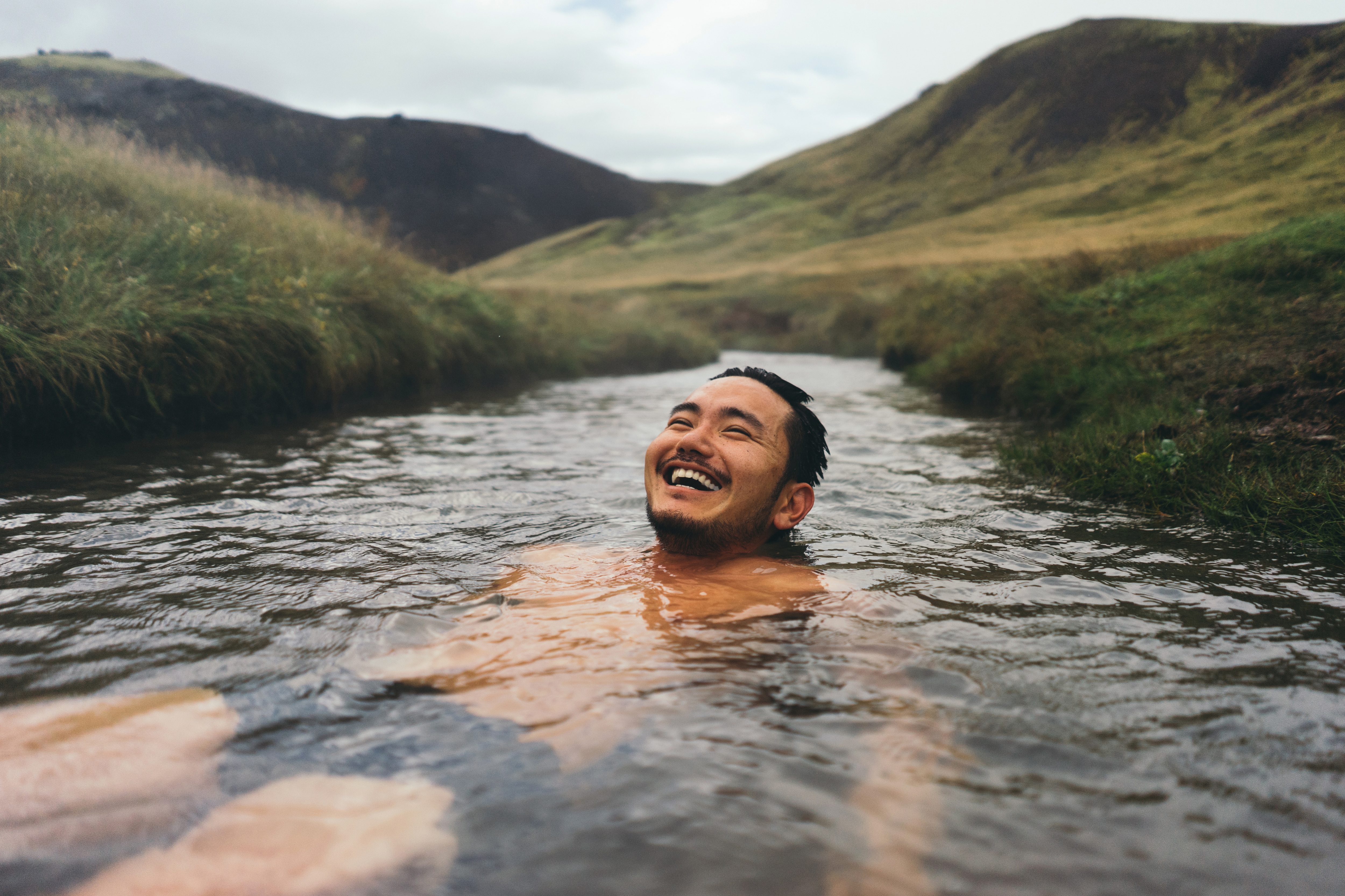 Man enjoying a hot spring relaxation after arriving at his destination with Virgin Australia