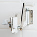 A metal Swing-A-Way wall mount can opener with a white handle.