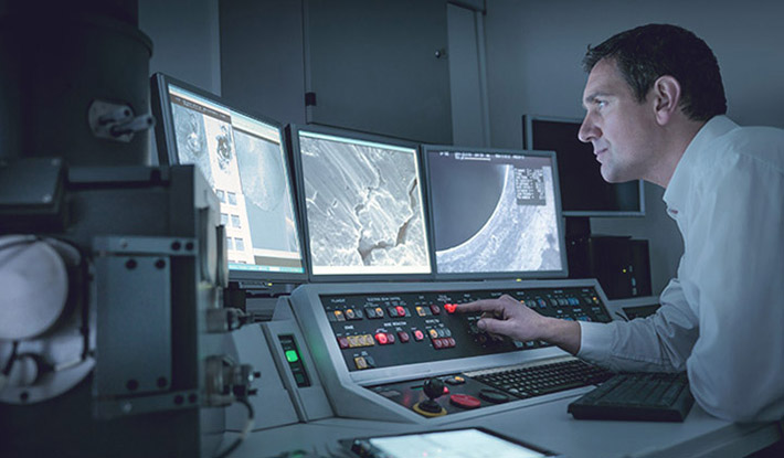 Man viewing screens with electron microscope