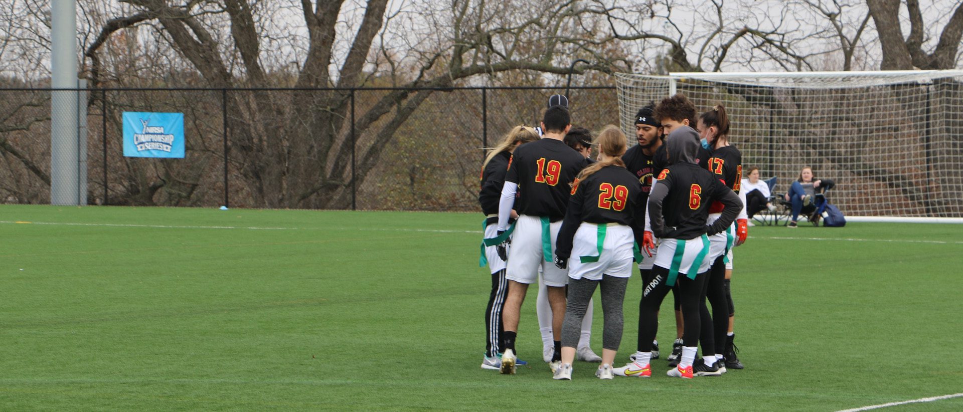 flag football team huddled up together on a field