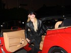 Toda de preto, Paris Hilton badala com sua Ferrari vermelha