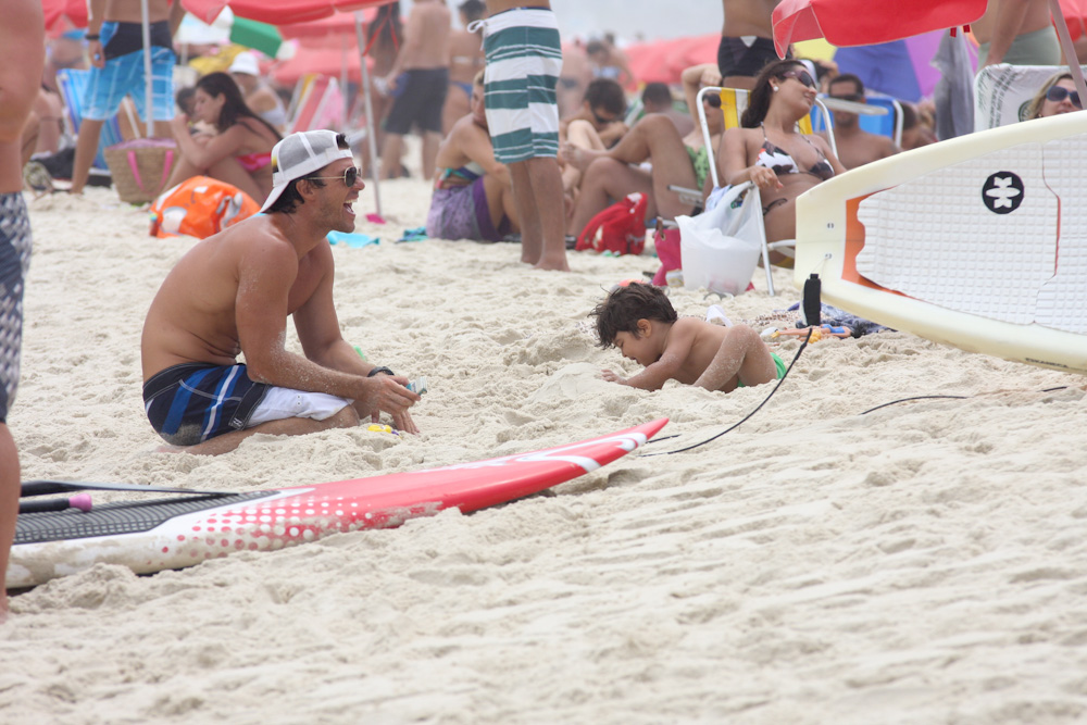 O marido de Juliana Paes, Carlos Eduardo Baptista, brinca com o filho, Pedro, na areia