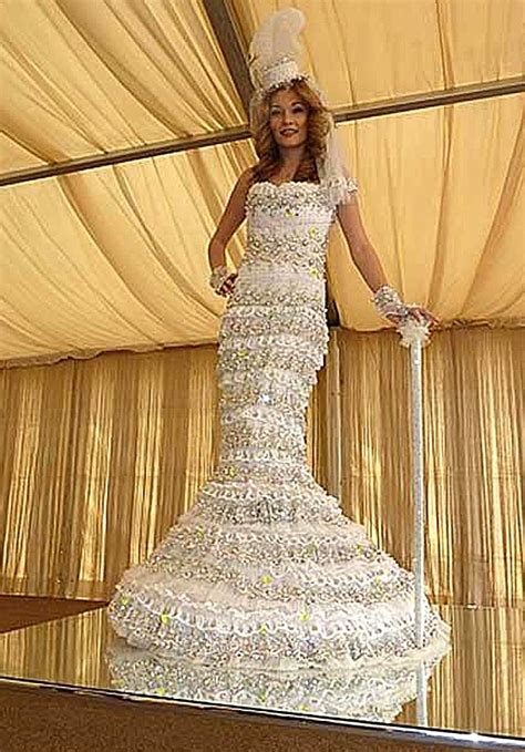 a woman in a wedding dress made out of hundreds of diapered objects is standing on a stage