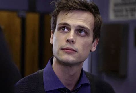 a man in a purple shirt and tie looking off to the side with an intense look on his face