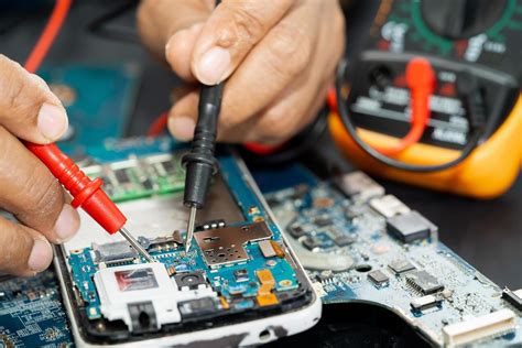 Technician repairing inside of mobile phone by soldering iron. Integrated Circuit. the concept ...