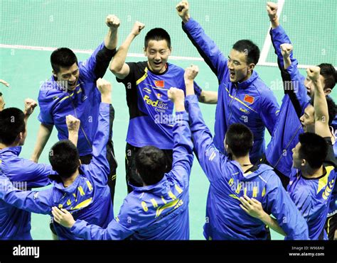 Chinese badminton players celebrate after defeating their English rivals in their Group A match ...